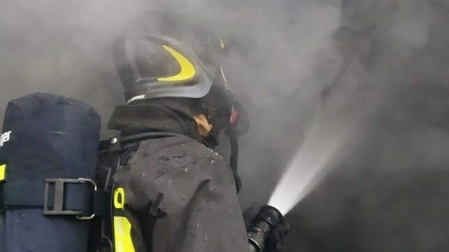 Un vigile del fuoco impegnato a spegnere un incendio (foto Borghesi)