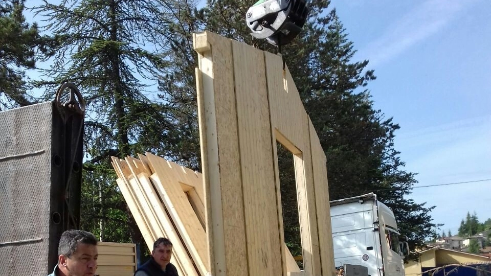 Il montaggio della casa in legno donata a Posta