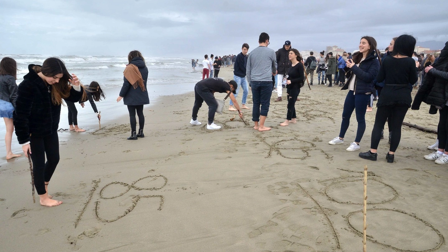 Studenti scrivono il voto desiderato in spiaggia (Foto Umicini)