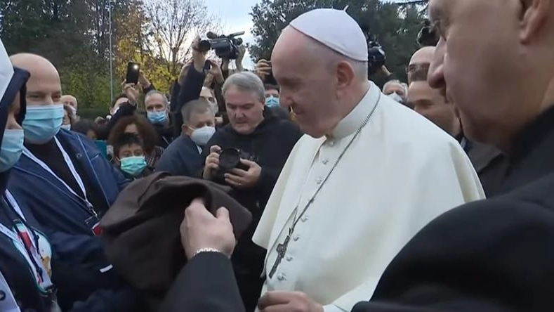 Papa Francesco mentre riceve un saio ad Assisi