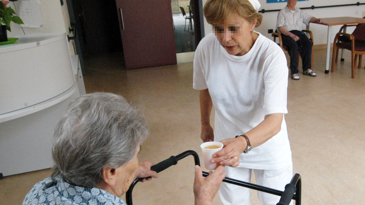 Una infermiera mentre assiste una ospite di una Rsa (foto d’archivio)