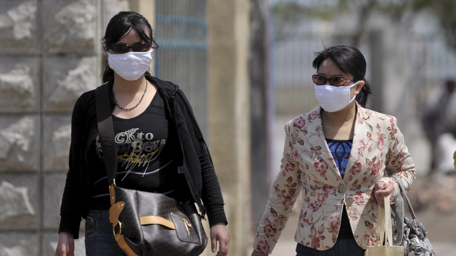 Passanti con la mascherina in una città della Cina 