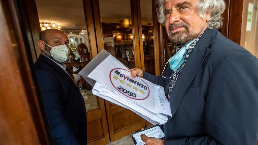 Beppe Grillo con il nuovo logo del M5S (Ansa)