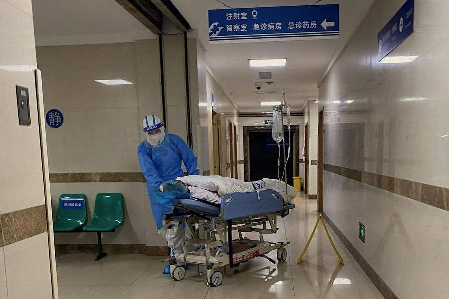 Covid, sanitari in Cina trasportano un paziente (Ansa)