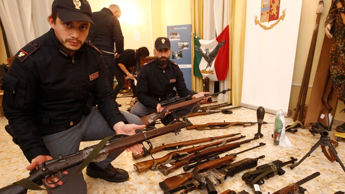 Poliziotti mostrano parte dell'arsenale recuperato (Foto Lazzeroni)