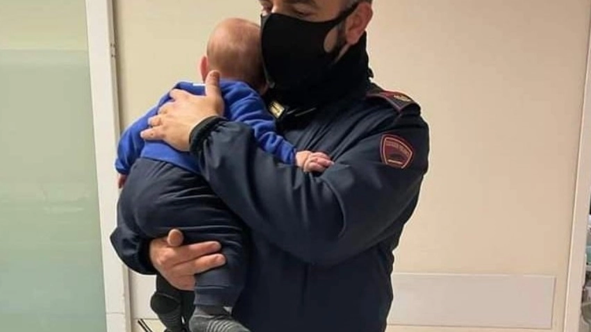 La foto del bambino in braccio al poliziotto