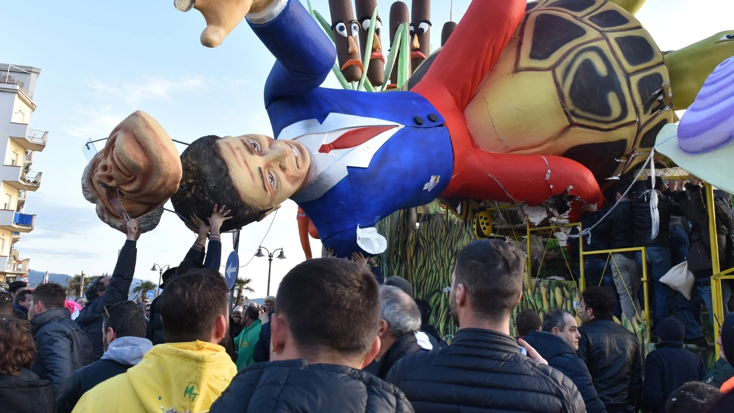 Il mascherone di Gentiloni-Renzi caduto sulla folla che stava assistendo alla prima sfilata (Agostini)