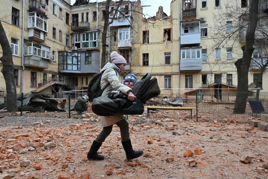 Una mamma in fuga col suo bambino in Ucraina (Ansa)
