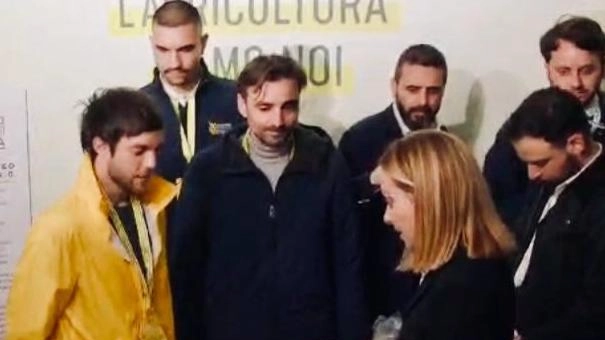 A sinistra Mattia Lusini che spiega a Giorgia Meloni come lavorano i suoi droni