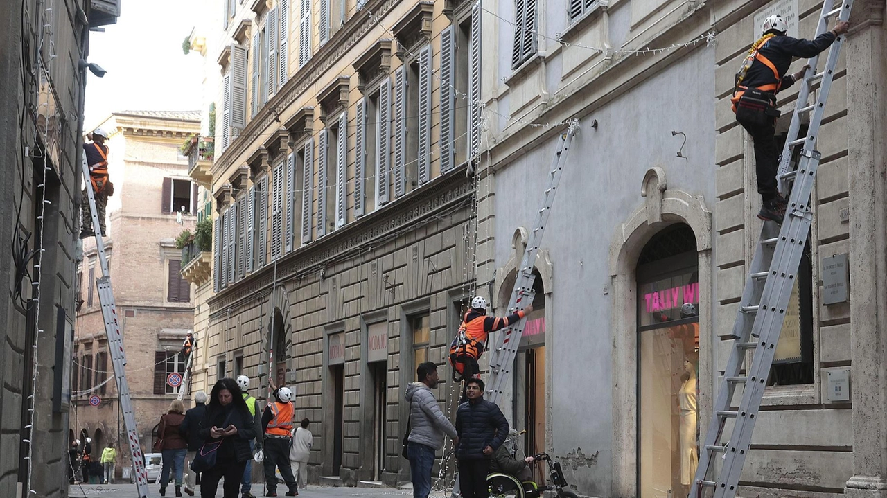 Gli operai ieri al lavoro per le vie del centro per mettere i ventagli di luci Gli operai ieri al lavoro per le vie del centro per mettere i ventagli di luci