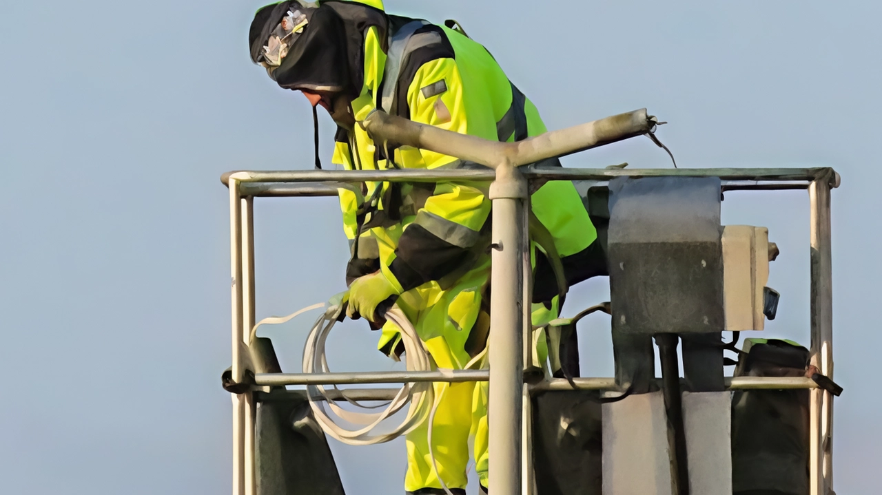 Un operaio al lavoro su un lampione della pubblica illuminazione Un operaio al lavoro su un lampione della pubblica illuminazione