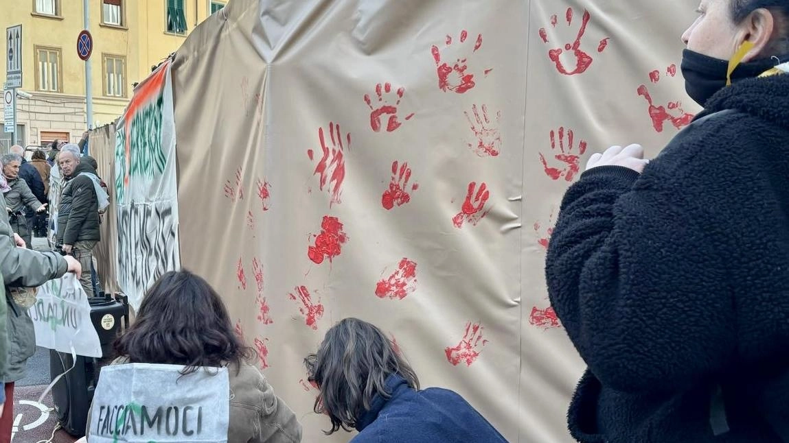 Le impronte con vernice rossa lasciate dai manifestanti sul recinto del cantiere Le impronte con vernice rossa lasciate dai manifestanti sul recinto del cantiere