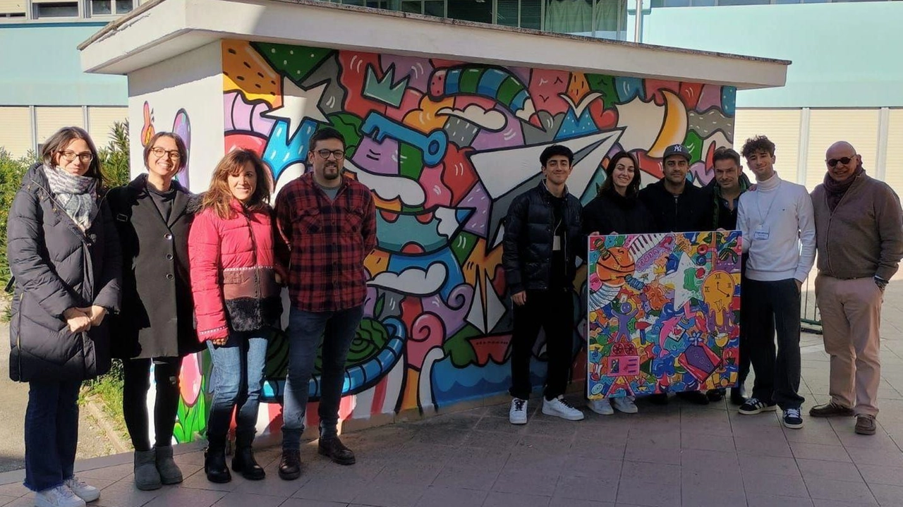L’opera realizzata da Skim con alcuni studenti del liceo XXV Aprile di Pontedera sul muro di un locale a servizio dell’edificio della scuola L’opera realizzata da Skim con alcuni studenti del liceo XXV Aprile di Pontedera sul muro di un locale a servizio dell’edificio della scuola