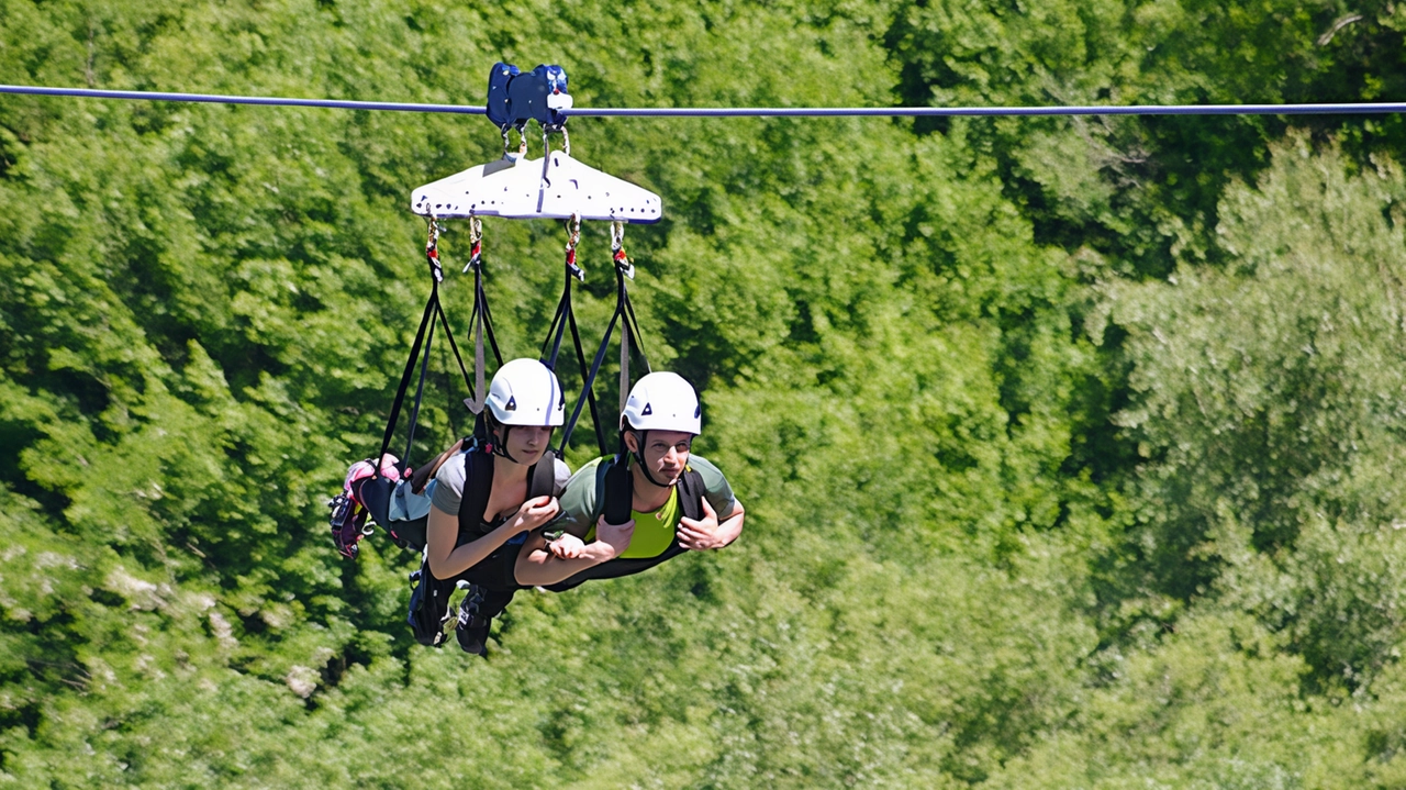 Due turisti che. sorvolano il lago di Vagli con la zip line Due turisti che. sorvolano il lago di Vagli con la zip line