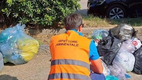 Un ispettore ambientale. verifica alcuni sacchetti abbandonati (foto d’archivio) Un ispettore ambientale. verifica alcuni sacchetti abbandonati (foto d’archivio)