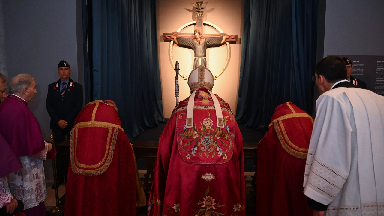 Un momento di preghiera davanti al Volto Santo con il vescovo Paolo Giulietti al termine della Processione di sabato sera (foto Alcide)
