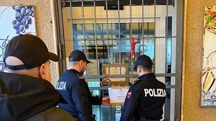Gli uomini della polizia mentre appongono i sigilli di chiusura per cinque giorni al locale finito in numerose segnalazioni da parte delle forze dell’ordine, nelle settimane scorse