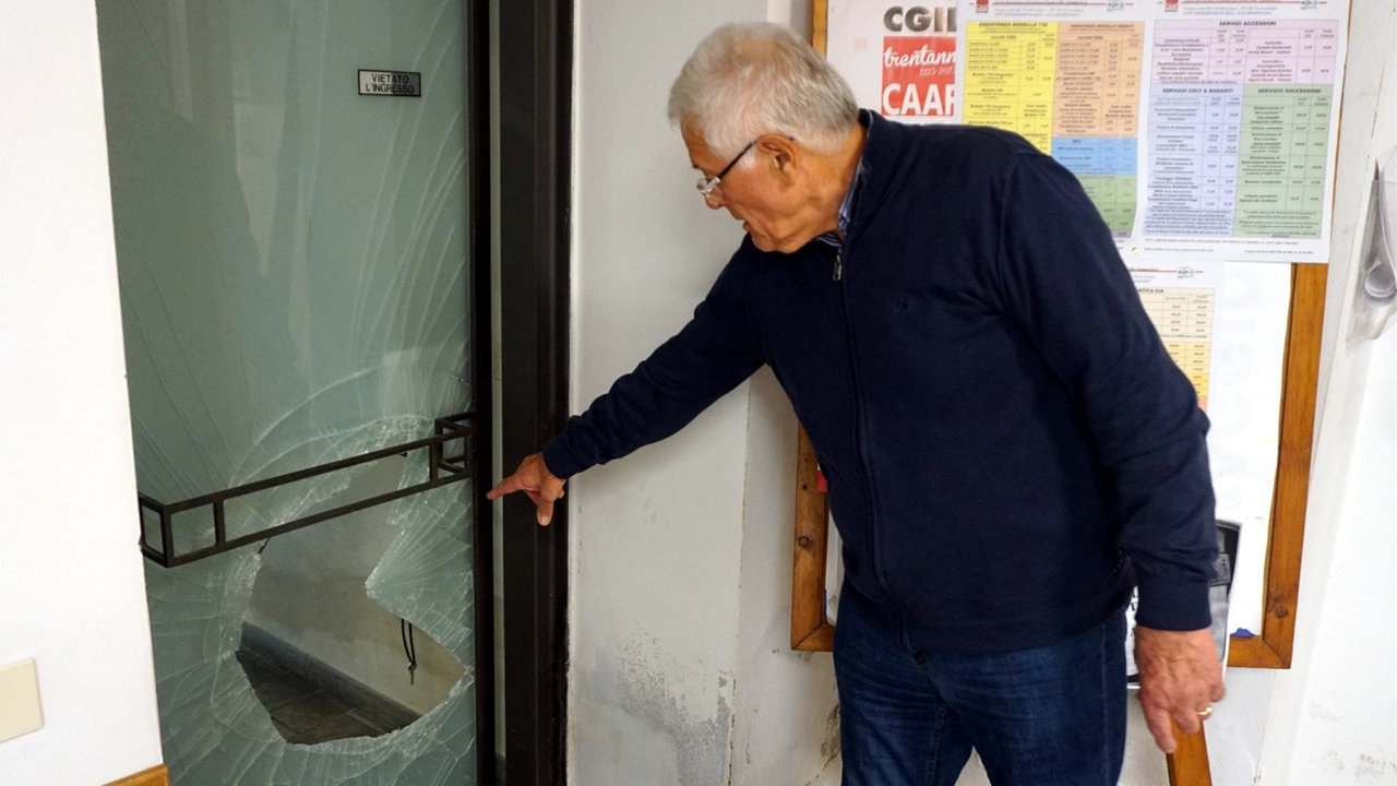 Un uomo mostra con la mano la porta danneggiata da chi la notte tra giovedì e venerdì è entrato nella sede della Cgil alla ricerca di oggetti da rubare Un uomo mostra con la mano la porta danneggiata da chi la notte tra giovedì e venerdì è entrato nella sede della Cgil alla ricerca di oggetti da rubare