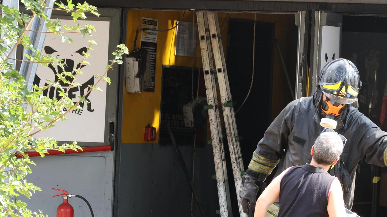 Un residente e i vigili del fuoco, che oltre a domare le fiamme hanno dovuto anche chiudere alcune vie del quartiere