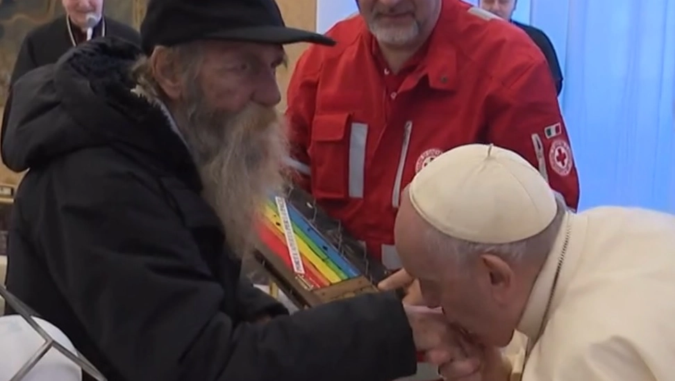 Le mani “sante” di Wue. Il bacio di Papa Francesco al clochard che aiuta i poveri