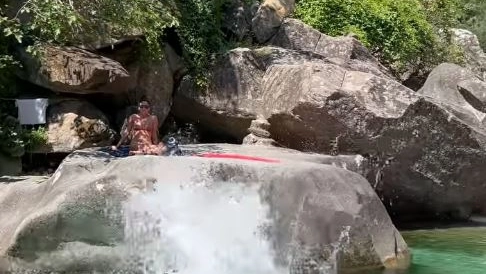 Bagnanti sugli scogli lungo il fiume Frigido a Guardine e la strada che scorre proprio sopra la loro testa Bagnanti sugli scogli lungo il fiume Frigido a Guardine e la strada che scorre proprio sopra la loro testa