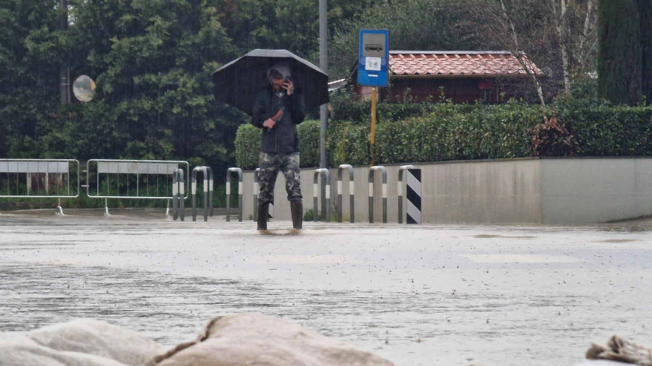 Sacchi di sabbia, stivali e ombrello per tentare di difendersi dalla furia dell’acqua (Acerboni / Fotocastellani)