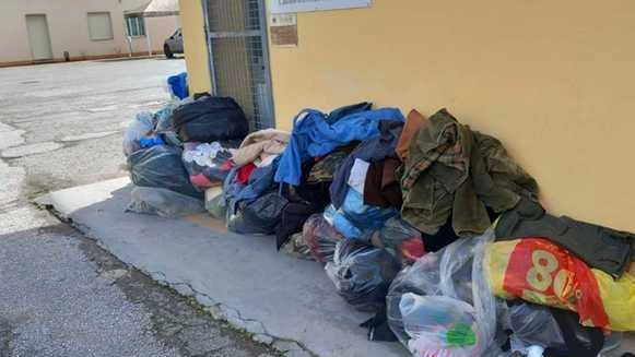 Alcuni capi di vestiario abbandonati come in una discarica davanti alla porta dell’associazione «Il Germoglio»