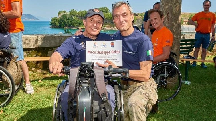 Il vomandante del Comsubin, contrammiraglio Stefano Frumento, sul promontorio del Varignano insieme a un disabile che ha preso parte allo stage precedente Il vomandante del Comsubin, contrammiraglio Stefano Frumento, sul promontorio del Varignano insieme a un disabile che ha preso parte allo stage precedente