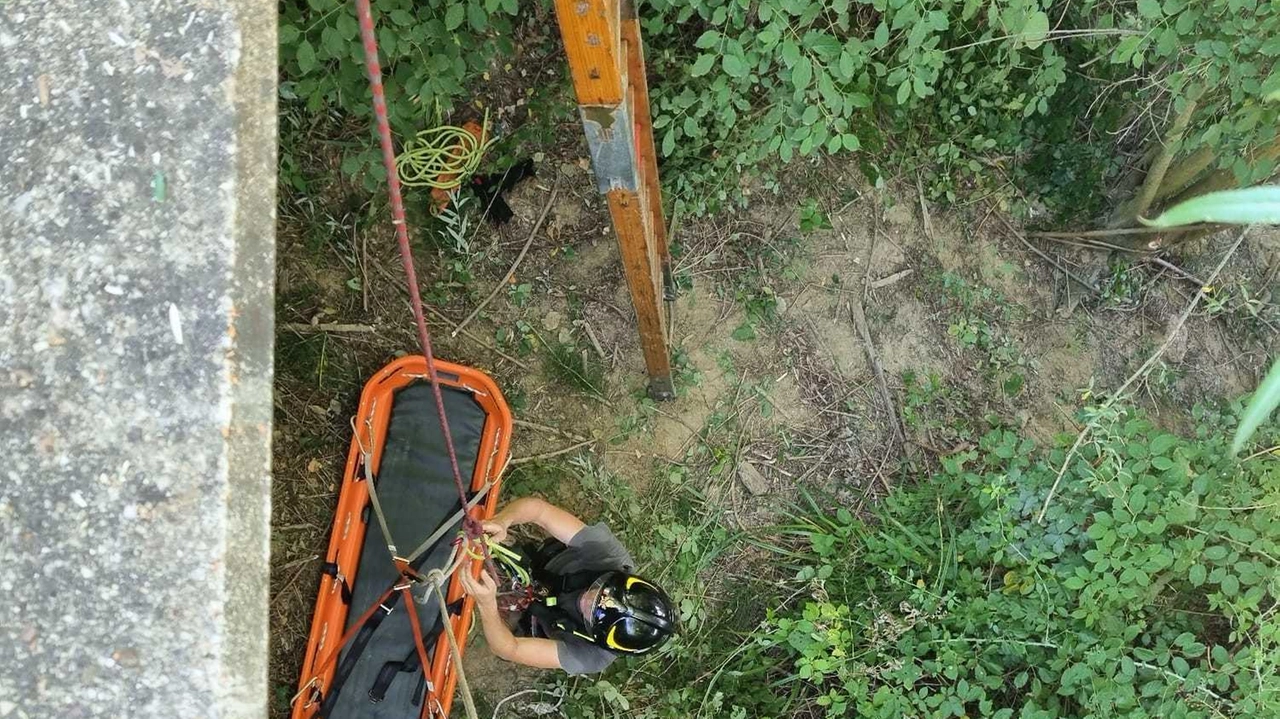 Un pompiere. si è appena calato giù dal cavalcavia con la barella toboga grazie a cui tre feriti sono stati tratti in salvo in sicurezza; a destra il minivan recuperato poco prima delle 13 Un pompiere. si è appena calato giù dal cavalcavia con la barella toboga grazie a cui tre feriti sono stati tratti in salvo in sicurezza; a destra il minivan recuperato poco prima delle 13