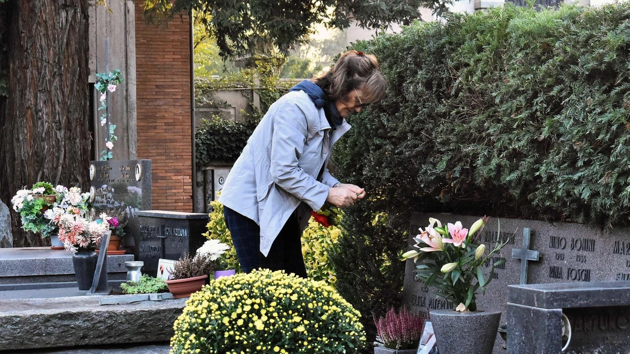 Una parente in visita alle tombe dei propri congiunti Una parente in visita alle tombe dei propri congiunti