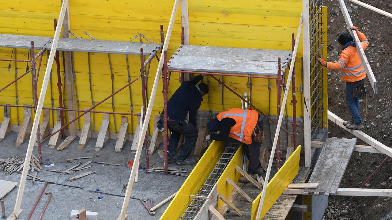 Operai al lavoro in un cantiere per la costruzione di un edificio (archivio) Operai al lavoro in un cantiere per la costruzione di un edificio (archivio)