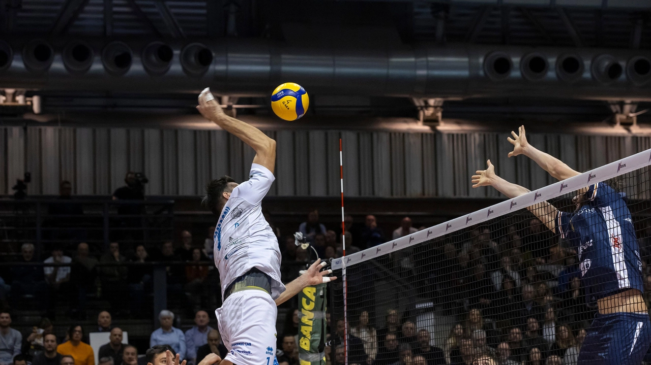 Un attaccante in volo e un muro pronto a fermarlo. Il momento decisivo di ogni partita di volley Un attaccante in volo e un muro pronto a fermarlo. Il momento decisivo di ogni partita di volley