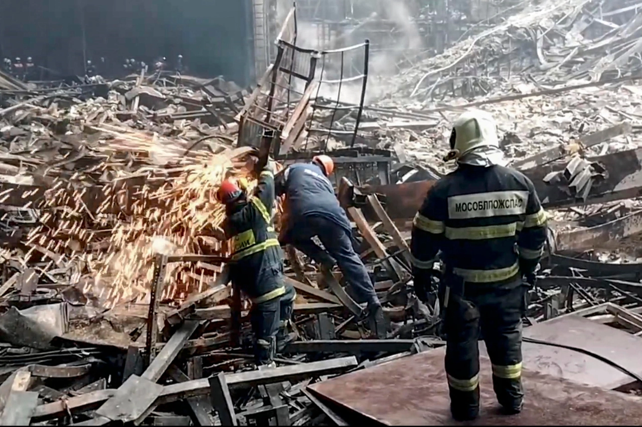 Vigili del fuoco e soccorritori al lavoro nella sala concerti di Mosca