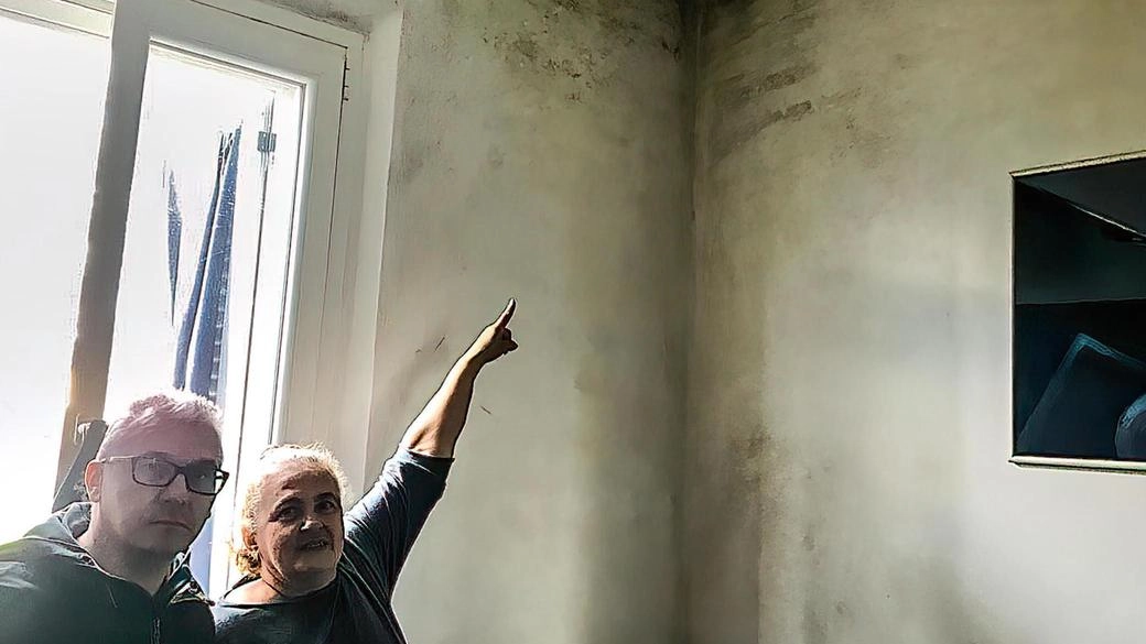 Antonietta Nicastro con Francesco Auletta mostra le macchie di umidità in una parete di una casa popolare Antonietta Nicastro con Francesco Auletta mostra le macchie di umidità in una parete di una casa popolare