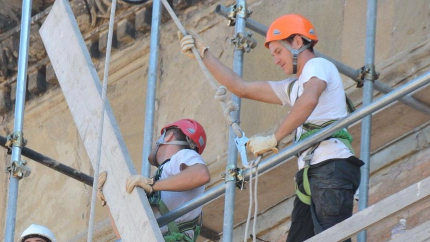 Nella foto d’archivio, operai al lavoro su un ponteggio Nella foto d’archivio, operai al lavoro su un ponteggio