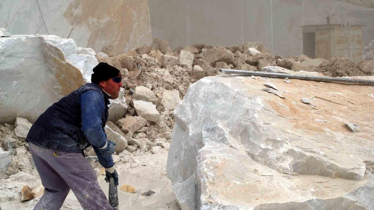 Un lavoratore impegnato in una cava di marmo Un lavoratore impegnato in una cava di marmo