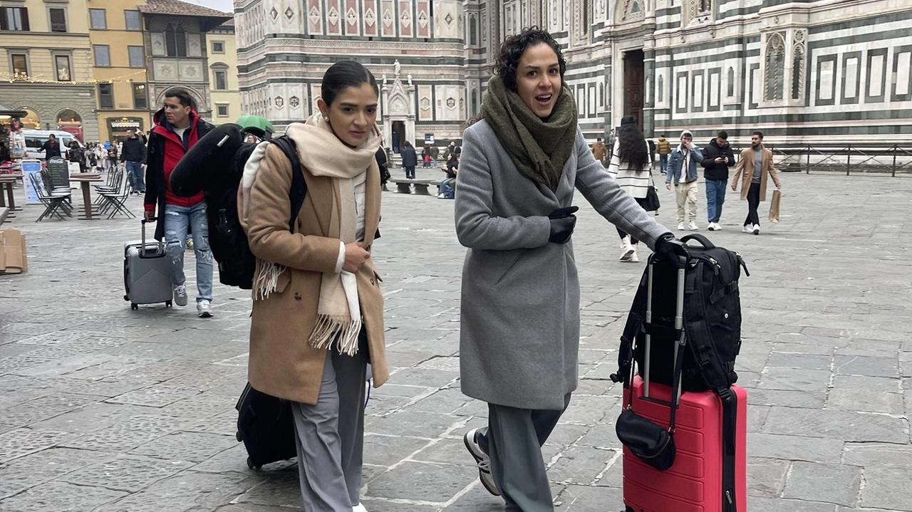 Due giovani turiste, con trolley d’ordinanza, in piazza del Duomo Due giovani turiste, con trolley d’ordinanza, in piazza del Duomo