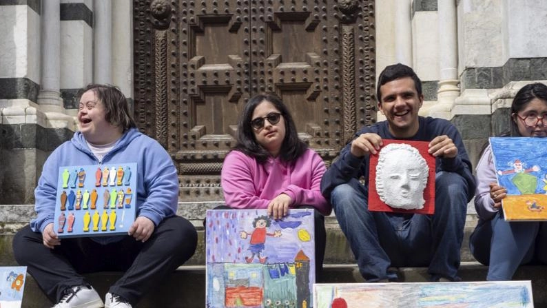 I ragazzi dell’associazione ’Il Sole’ mostrano le opere sui gradini del Battistero
