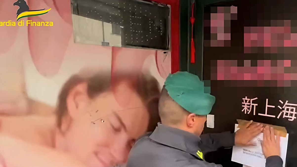 Un militare della guardia di finanza mentre appone i sigilli al centro massaggi in zona Stazione Un militare della guardia di finanza mentre appone i sigilli al centro massaggi in zona Stazione