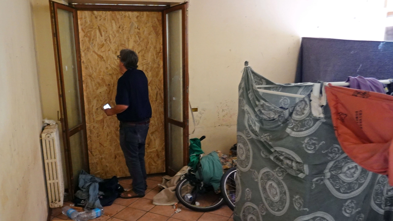Ostruiti con pannelli di legno alcuni accessi dei locali che ospitano i migranti. Nella foto don Massimo Biancalani (foto Luca Castellani/Fotocastellani)