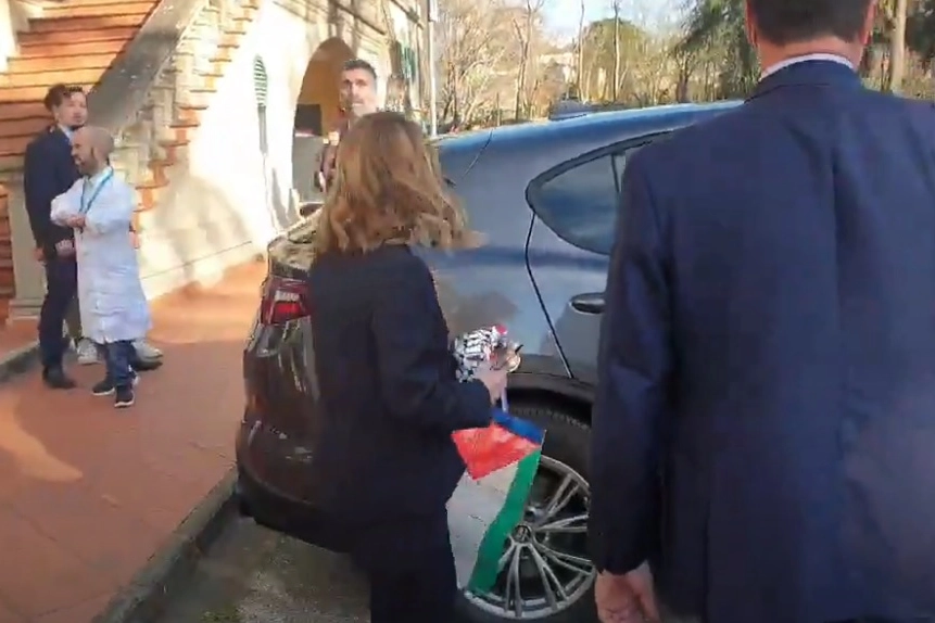 Giorgia Meloni esce dal Meyer con in mano una bandiera della Palestina