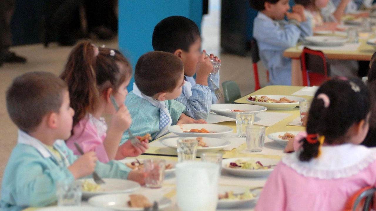 Bambini a tavola a una mensa scolastica Bambini a tavola a una mensa scolastica