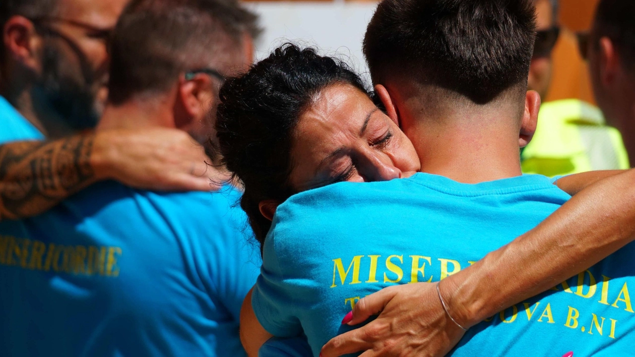 Due volontari si abbracciano, devastati dal dolore Due volontari si abbracciano, devastati dal dolore
