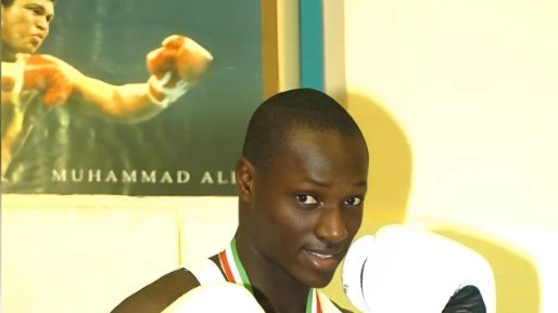 Ndiaye in posa davanti al poster di Muhammad Alì Ndiaye in posa davanti al poster di Muhammad Alì