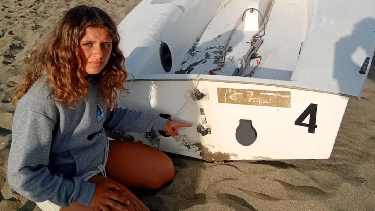 Una ragazza della Scuola Vela di Marina di Grosseto mostra il danno a una deriva