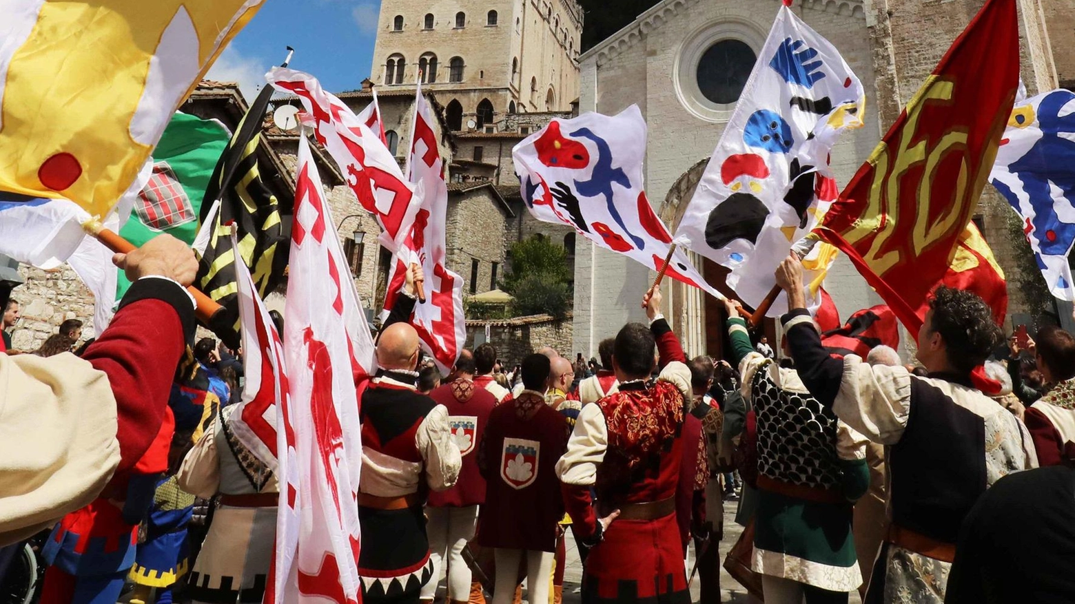 Il Gruppo sbandieratori di Gubbio celebra la tradizione e la spiritualità legate alla Festa dei Ceri, con una esibizione emozionante in piazza San Giovanni. Le bandiere consegnate dai presidenti delle associazioni locali aggiungono colore e significato all'evento.
