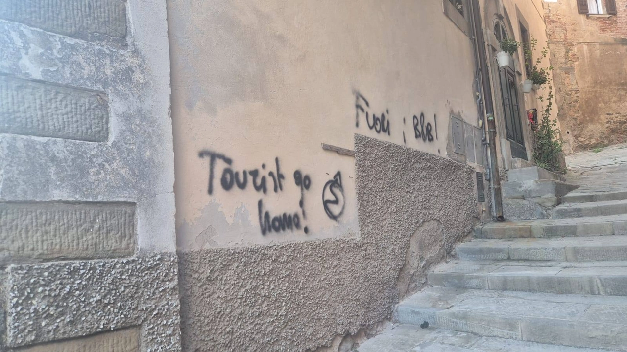 Le scritte contro l'overtourism sui muri di Cortona