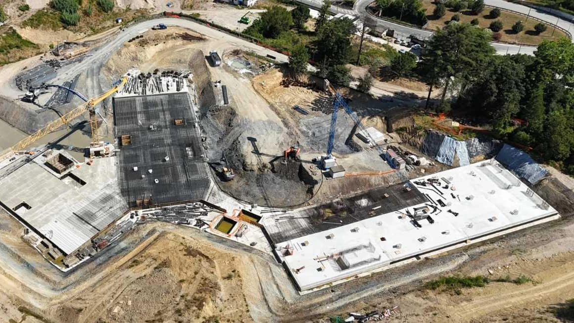 A sinistra, una panoramica dall’alto delle fondamenta del nuovo ospedale, realizzata con il drone. A destra, operai al lavoro all’interno del cantiere del Felettino A sinistra, una panoramica dall’alto delle fondamenta del nuovo ospedale, realizzata con il drone. A destra, operai al lavoro all’interno del cantiere del Felettino
