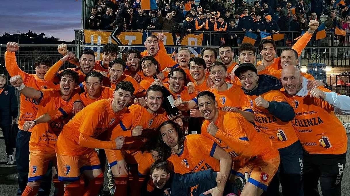 La squadra arancioblù festeggia sotto la tribuna il ritorno in Eccellenza