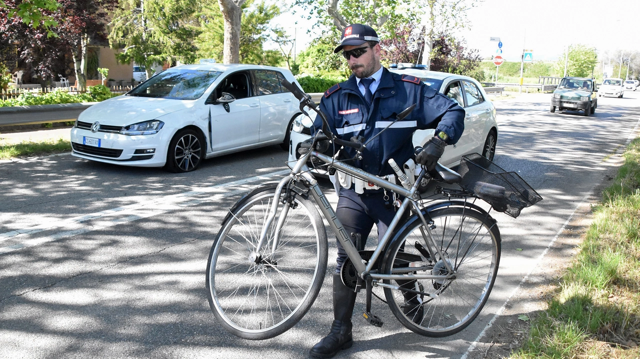 La bicicletta dell'uomo travolto e ucciso. Sullo sfondo, l'auto che lo ha investito (Foto Aprili)